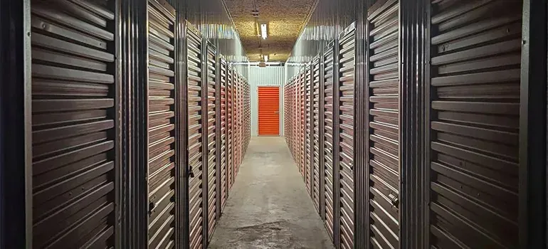 Self-storage corridor lined with metal roll-up unit doors