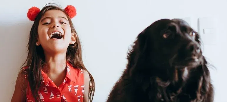 Laughing girl next to black dog
