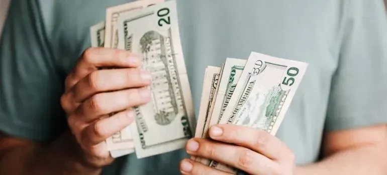 Hands fanning out twenty and fifty dollar bills