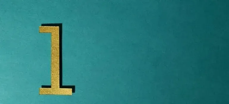 Gold number one on plain teal background