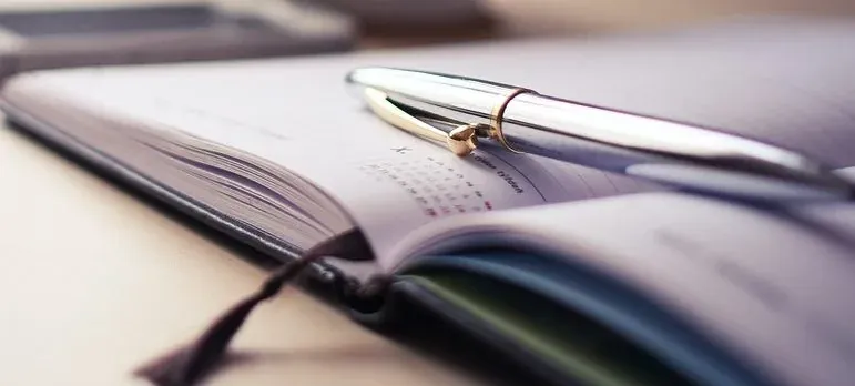 Pen resting on open planner notebook