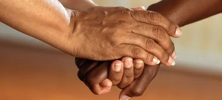 Close-up of two people's clasped comforting hands