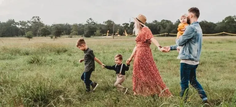 Family with three children walking through grassy field