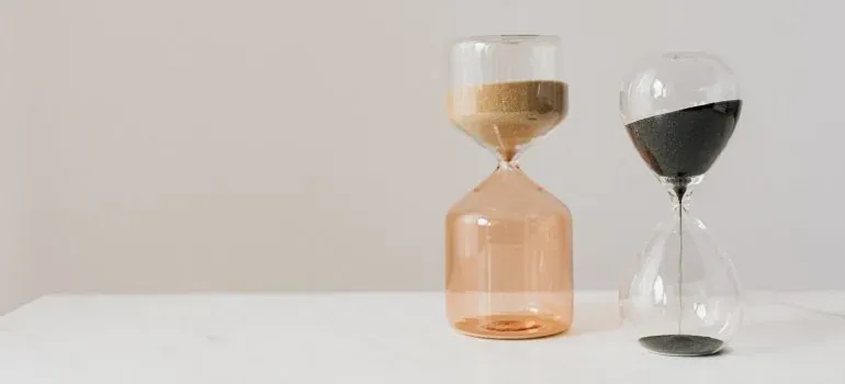 Two hourglasses on white table