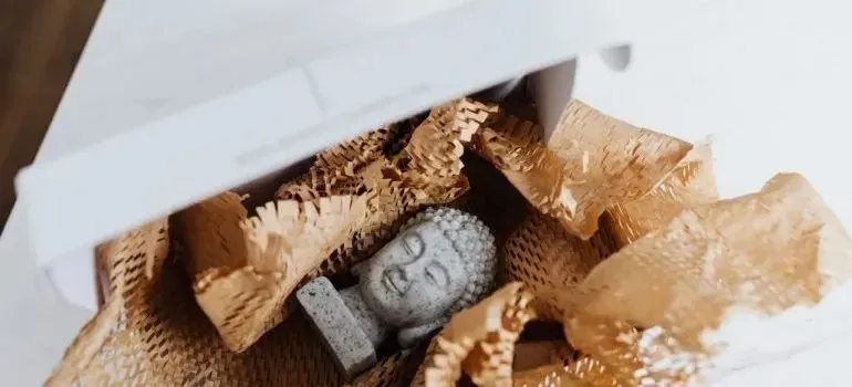 Buddha figurine packed in shredded paper inside box