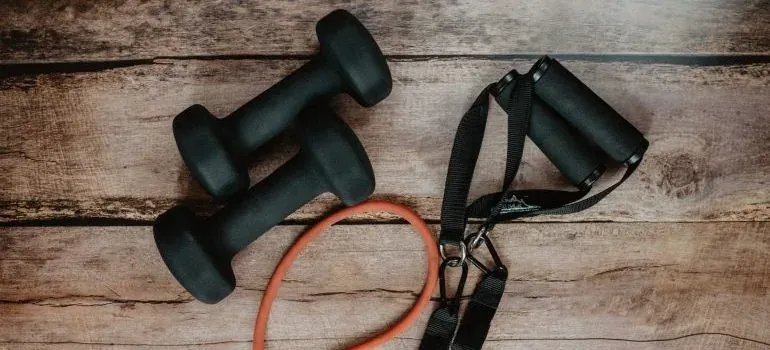 Dumbbells and resistance bands on wood