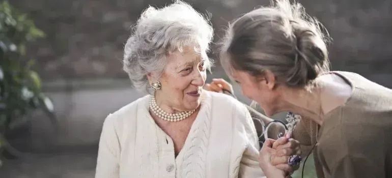 Two elderly women laughing together outdoors