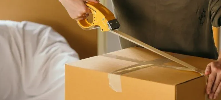 Person taping cardboard box shut