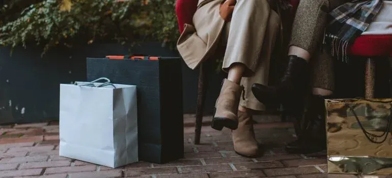 Shopping bags beside seated people