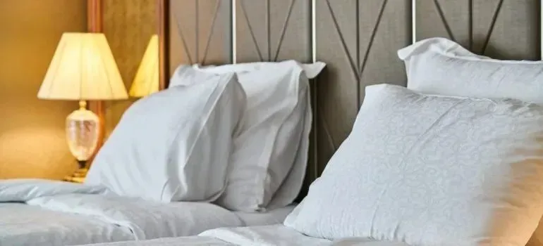 Hotel-style bed with white pillows and bedside lamp