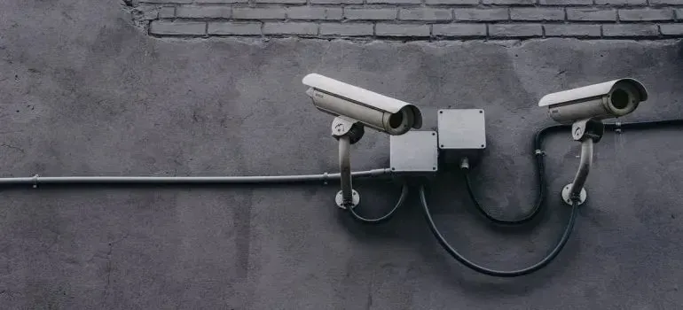 Two CCTV security cameras mounted on gray wall