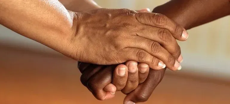 Close-up of two people's clasped hands