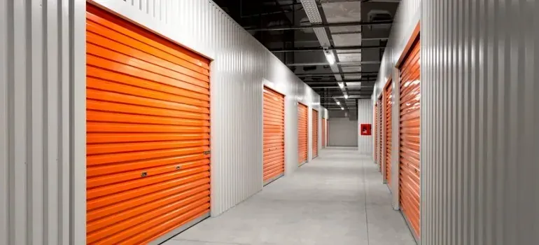 Self-storage corridor with orange roll-up unit doors