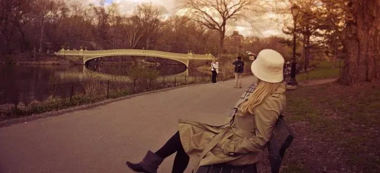 Woman on park bench near bridge