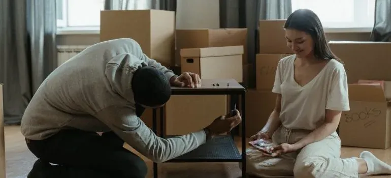 Couple assembling table among moving boxes