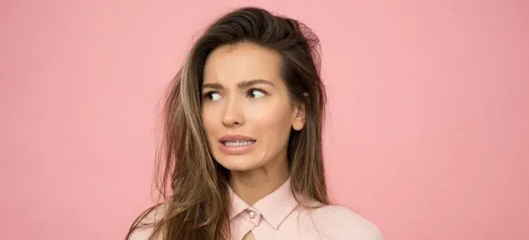 Worried woman on pink background