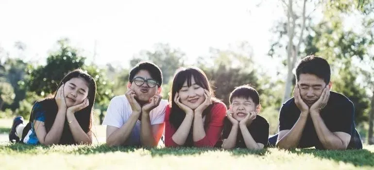Family of five lying on grass in park