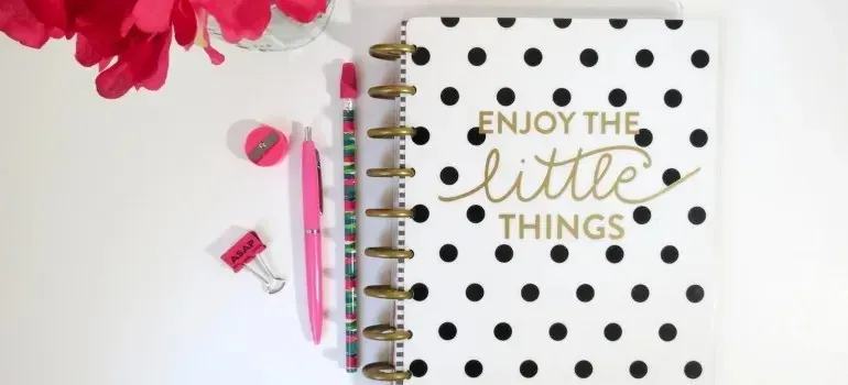 Polka-dot planner with pink pens, stationery flat lay