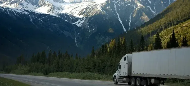Unmarked white semi-trailer truck on mountain highway