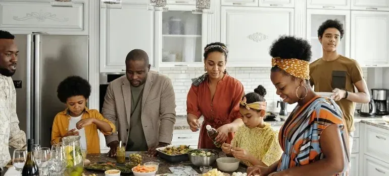 Multigenerational family cooking together in white kitchen