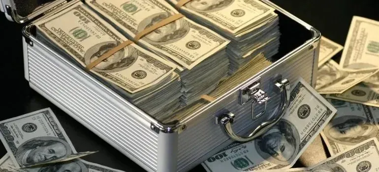 Metal briefcase overflowing with hundred-dollar bills