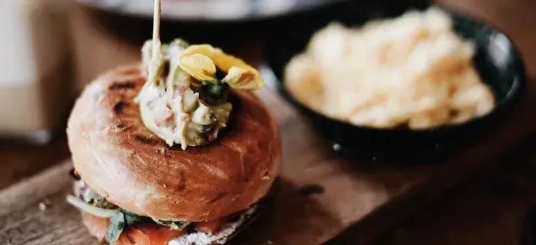 Bagel sandwich with potato chips on wooden board