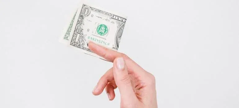 Hand holding folded dollar bill