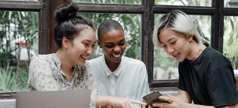 Three friends laughing at phone