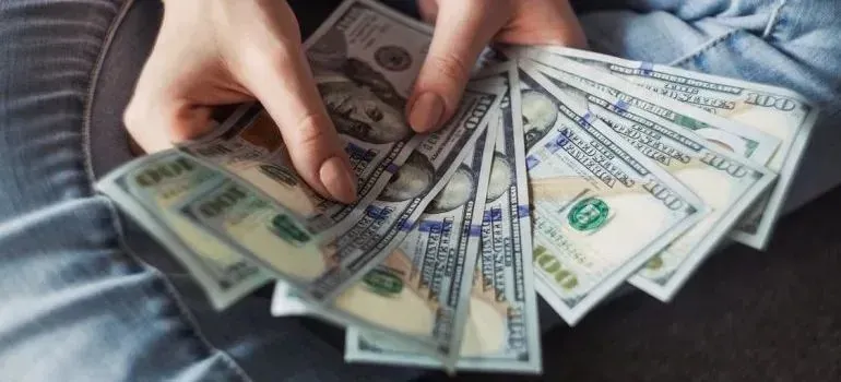 Hands fanning out hundred-dollar bills