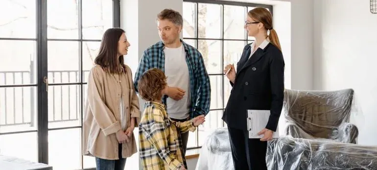 Agent with clipboard talking to family in new home