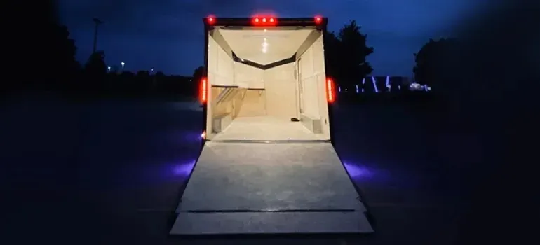 Open lighted cargo trailer with ramp at night