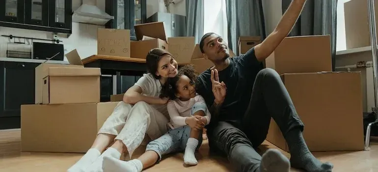 Family taking selfie among moving boxes in new kitchen