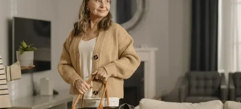 Older woman holding a bag in bright living room