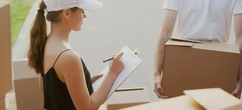 Woman with clipboard taking inventory beside a mover