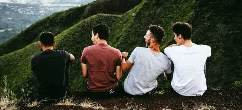Four friends sitting on hillside