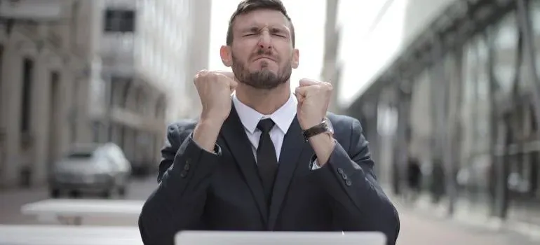 Excited businessman clenching fists outdoors