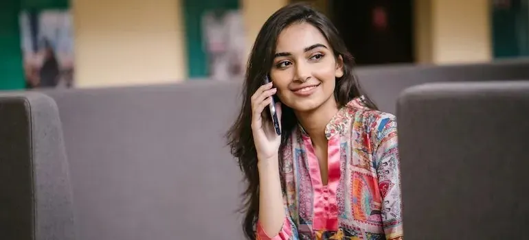 Young woman in colorful blouse talking on phone