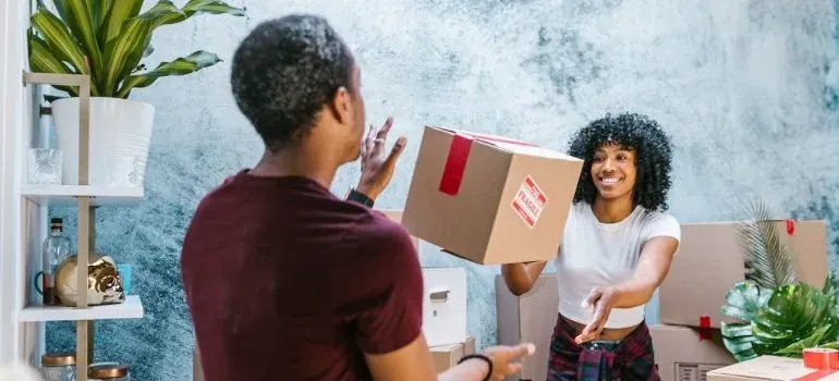 Man handing fragile-stickered box to smiling woman