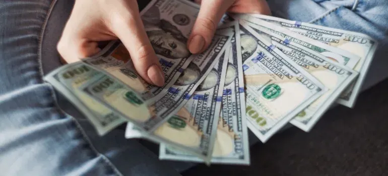 Hands fanning hundred dollar bills