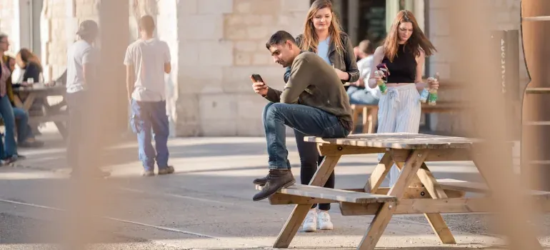 People at outdoor picnic table with phones