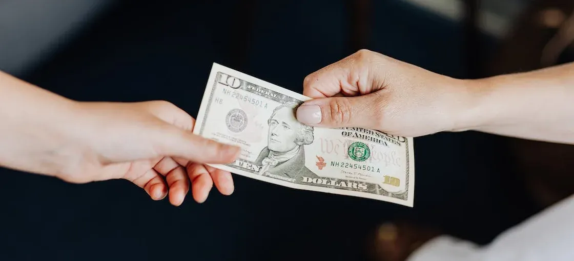 Hands exchanging ten dollar bill