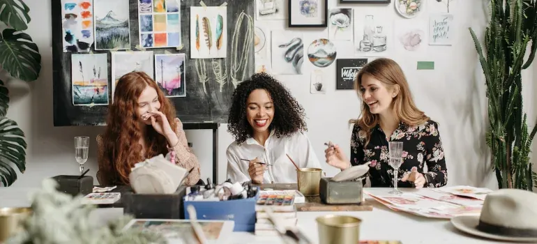 Three women painting at art studio table