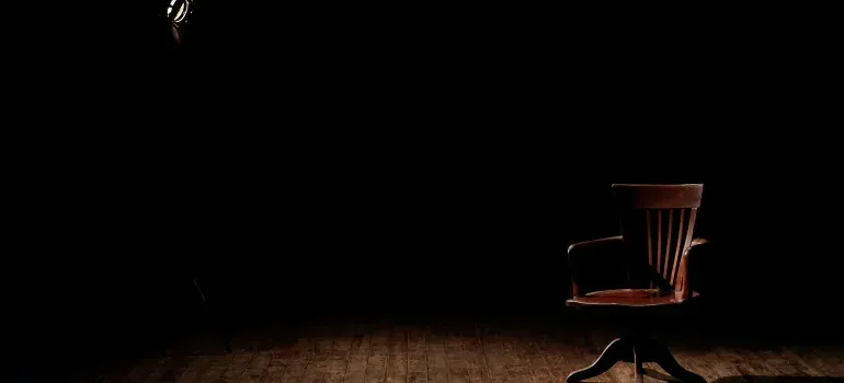 Spotlit wooden chair on dark stage