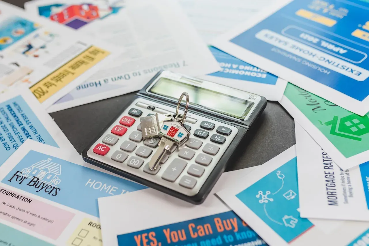 Calculator and house keys on real-estate flyers