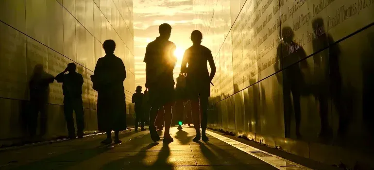 Silhouettes walking through memorial at sunset