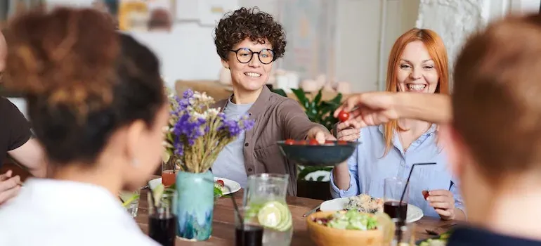 Friends sharing salad at dinner table