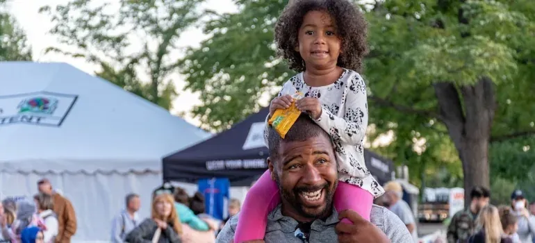 Father with child on shoulders at fair