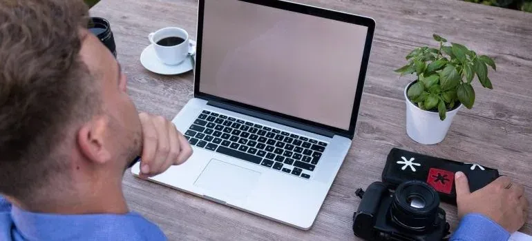 Man at laptop with camera and plant