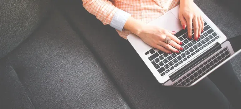 Woman typing on laptop on couch