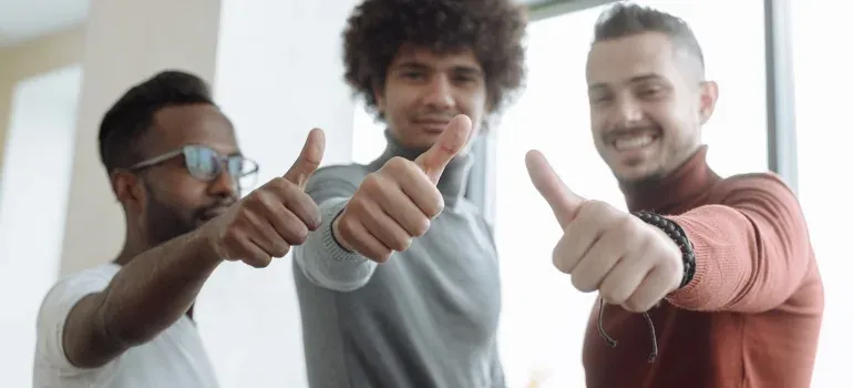 Three men giving thumbs up